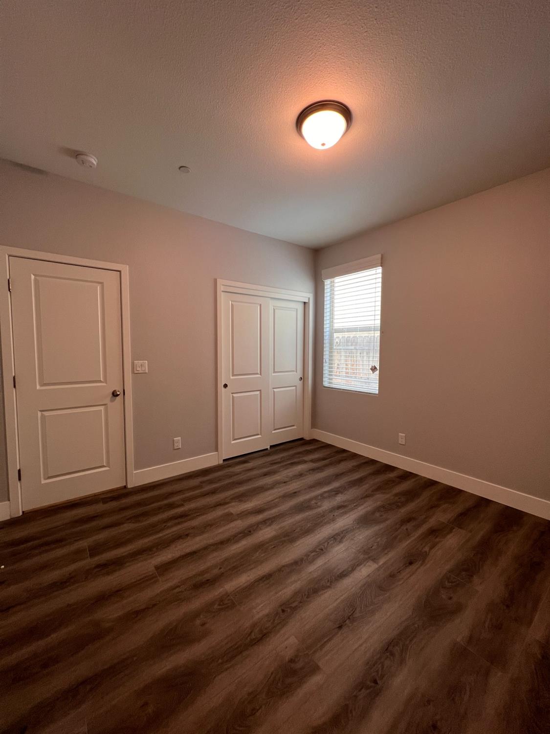445 Expedition Avenue Madera, CA 93636 - Photo 11 of 36 an empty room with wooden floor and windows