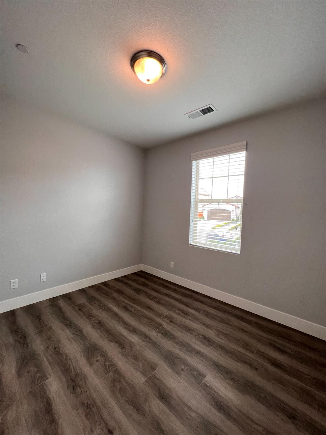 445 Expedition Avenue Madera, CA 93636 - Photo 8 of 36 a view of an empty room with wooden floor and a window