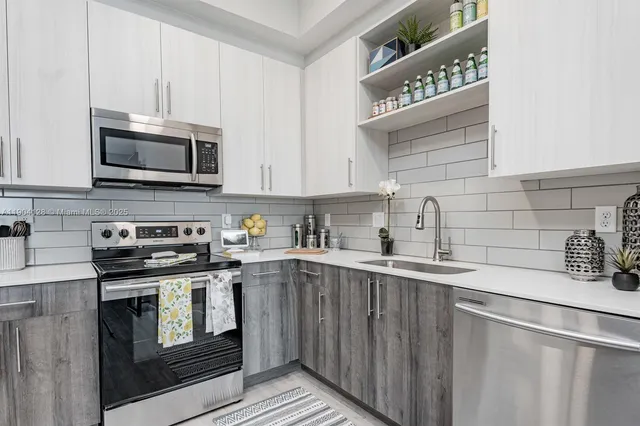 a kitchen with granite countertop a sink a stove and cabinets