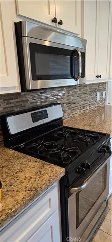 a stove top oven sitting inside of a kitchen