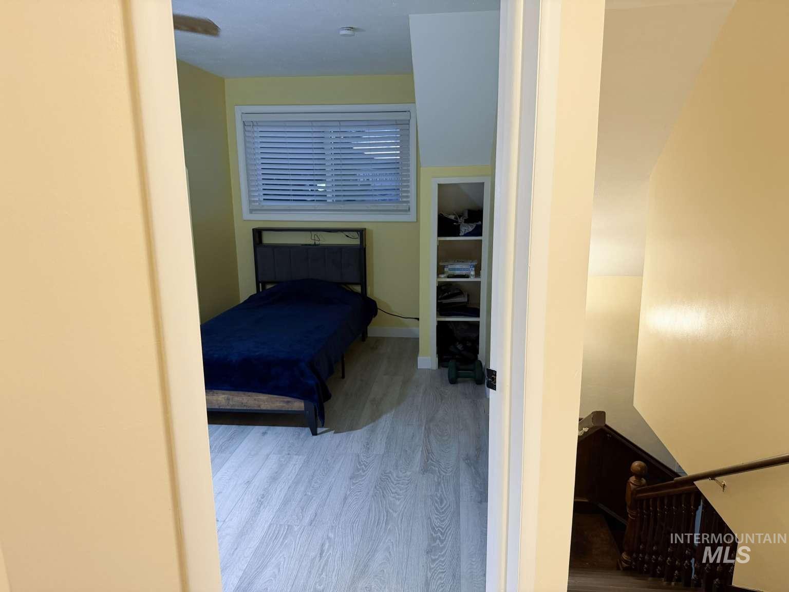 1158 South Powerline Road Nampa, ID 83686 - Photo 32 of 46 Room featuring wood-finish flooring, a window with blinds, and built-in shelving