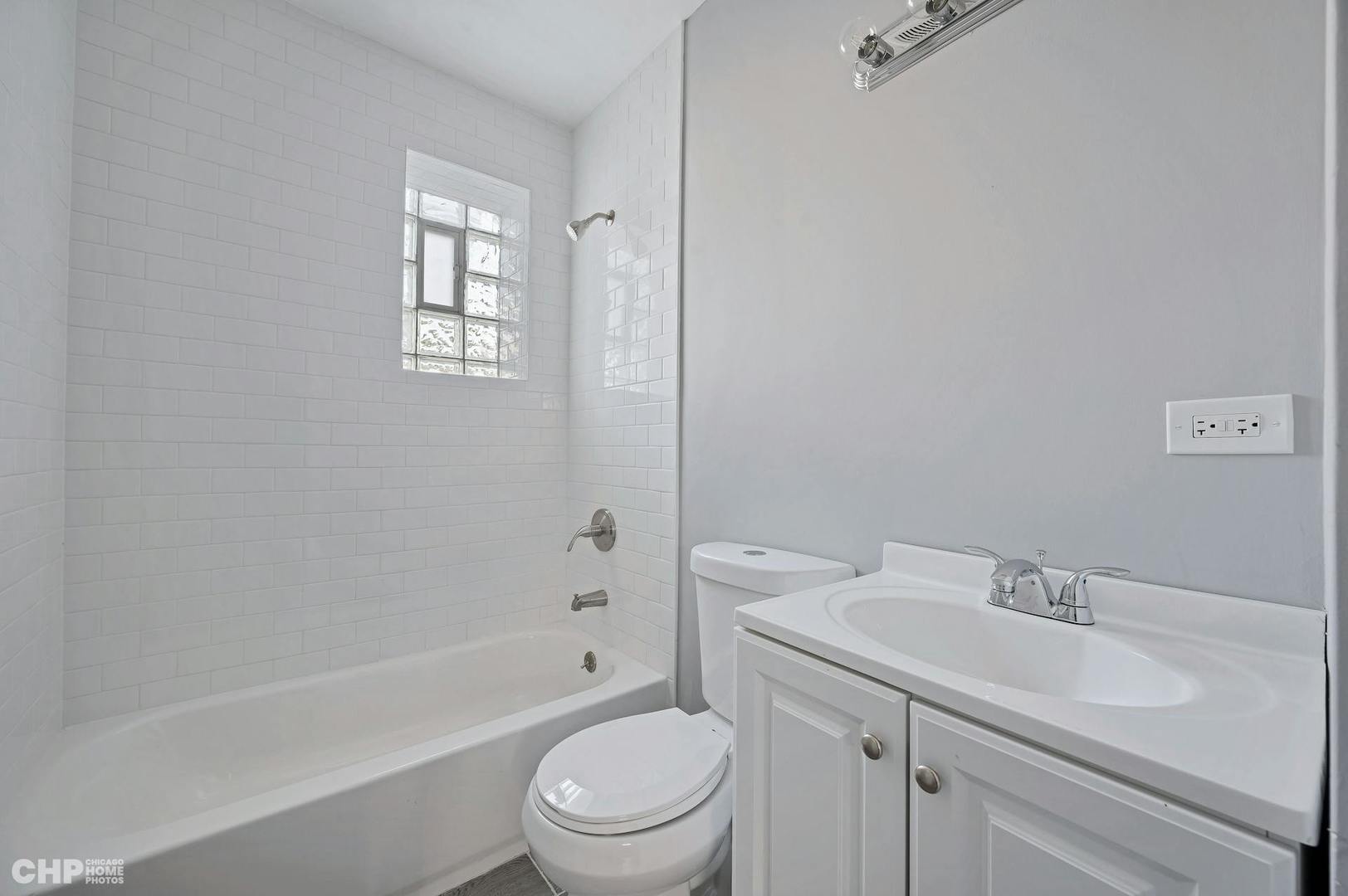 16 East 118th Place, Unit 1F Chicago, IL 60628 - Photo 4 of 10 a bathroom with a sink toilet and shower