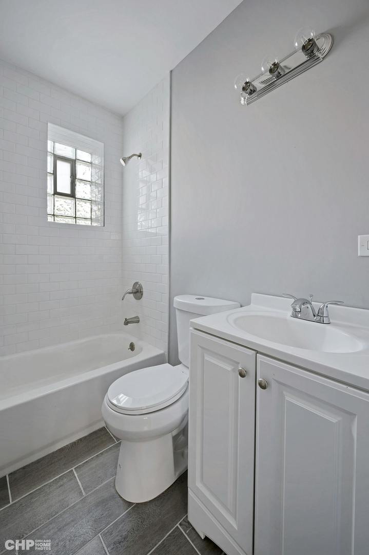 16 East 118th Place, Unit 1F Chicago, IL 60628 - Photo 5 of 10 a bathroom with a sink toilet and shower