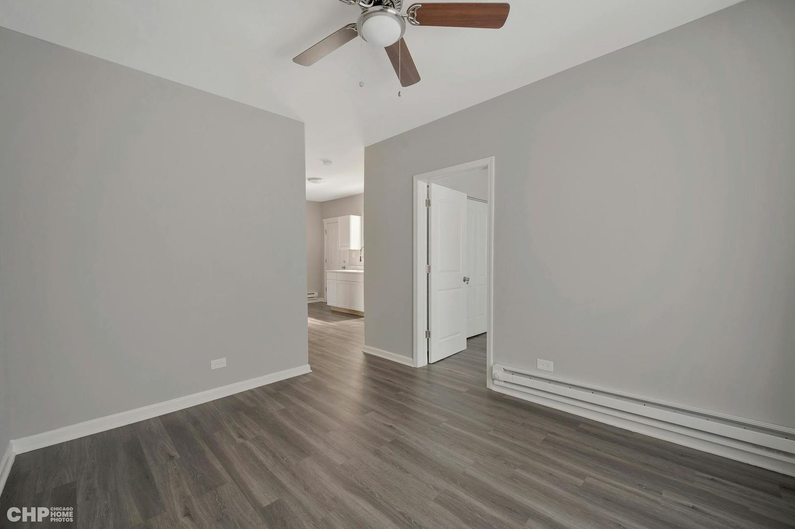 16 East 118th Place, Unit 1F Chicago, IL 60628 - Photo 6 of 10 wooden floor in an empty room