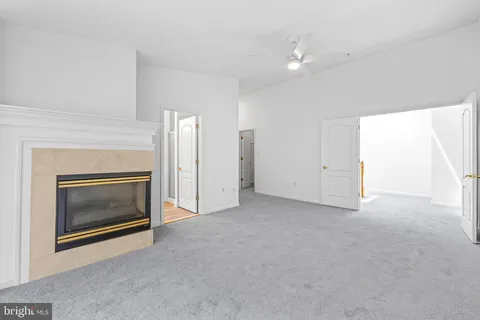 a view of an empty room with a fireplace and a window