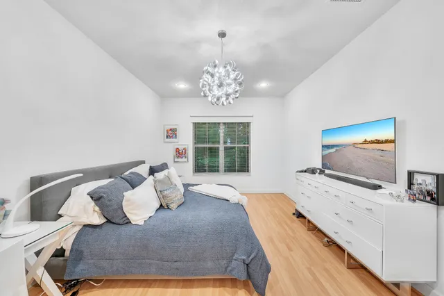 a bedroom with a bed and a chandelier