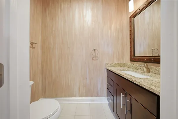a bathroom with a granite countertop sink and a toilet