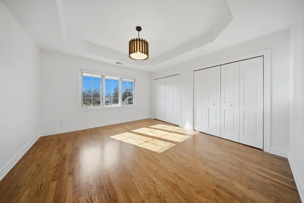 a view of empty room with wooden floor and window