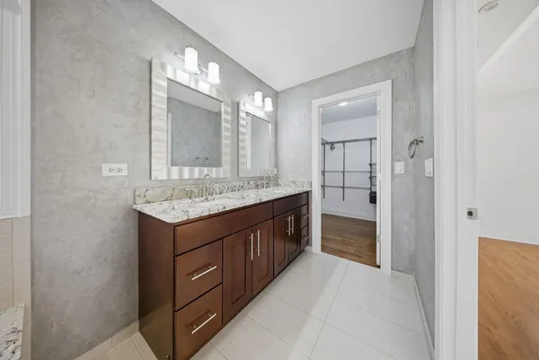 a bathroom with a granite countertop double vanity sink and a mirror