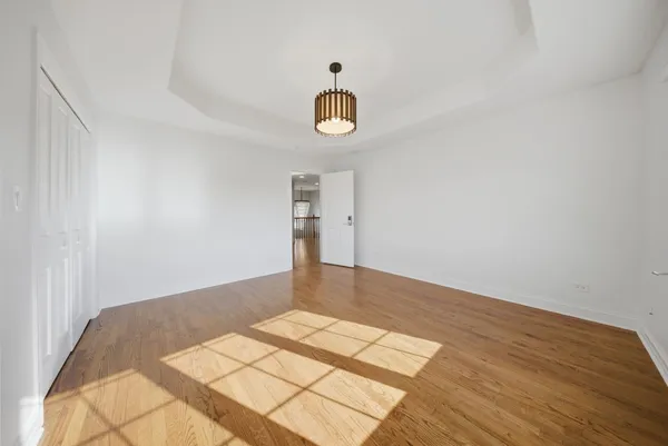a view of a room with wooden floor and white walls