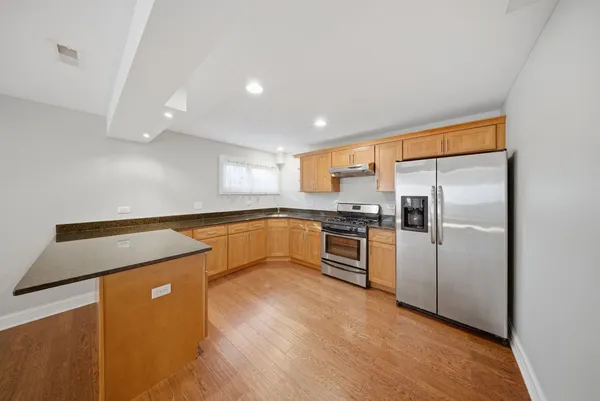 a kitchen with stainless steel appliances a refrigerator sink and microwave