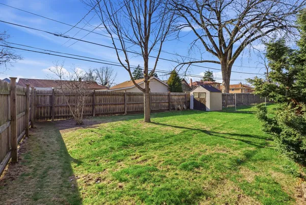 a view of a backyard with wooden fence