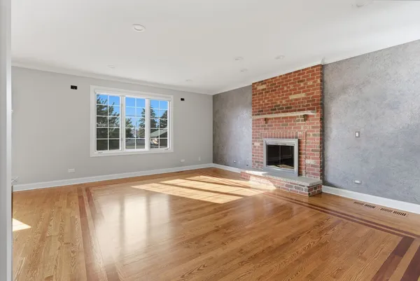 a view of empty room with a fireplace and wooden floor