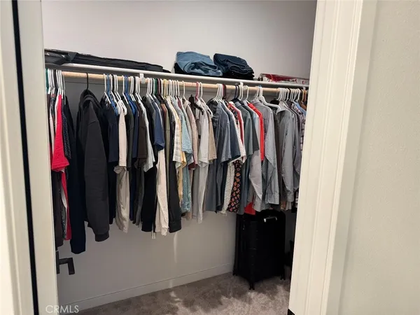 a view of walk in closet with clothes