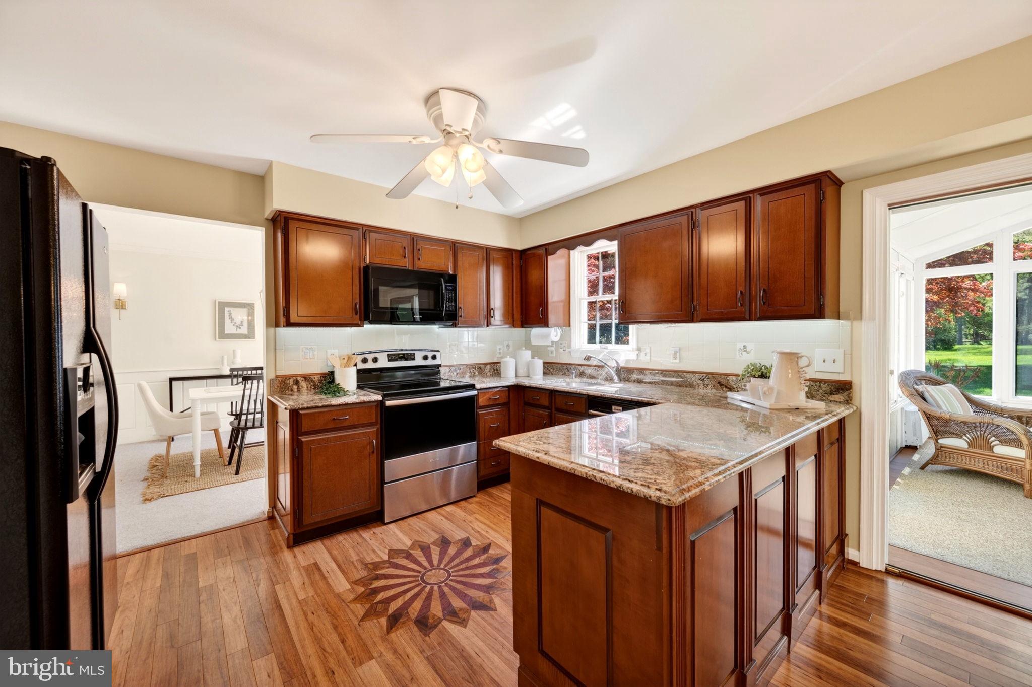 3805 Duddington Way Phoenix, MD 21131 - Photo 19 of 69 a kitchen with stainless steel appliances granite countertop a stove top oven a sink dishwasher a dining table and chairs with wooden floor