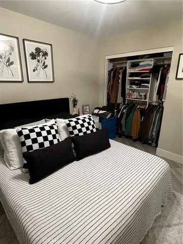 a bedroom with a bed and a black white couch