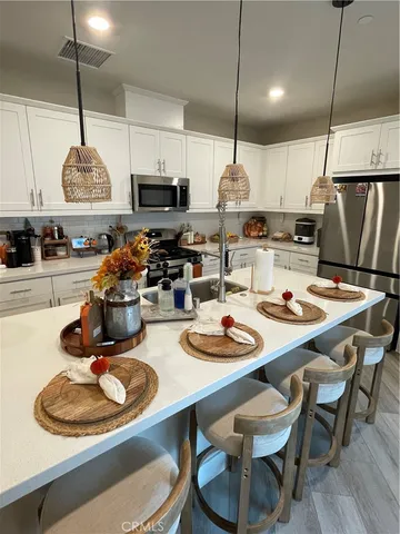 a kitchen with white cabinets and appliances
