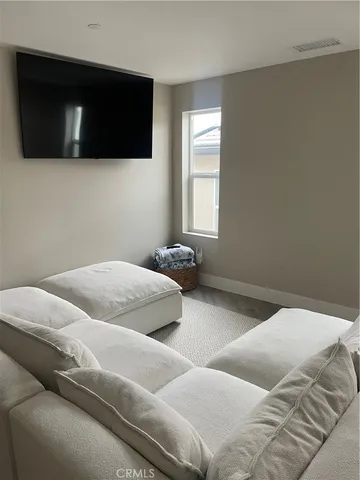 a bedroom with a bed a flat screen tv and window
