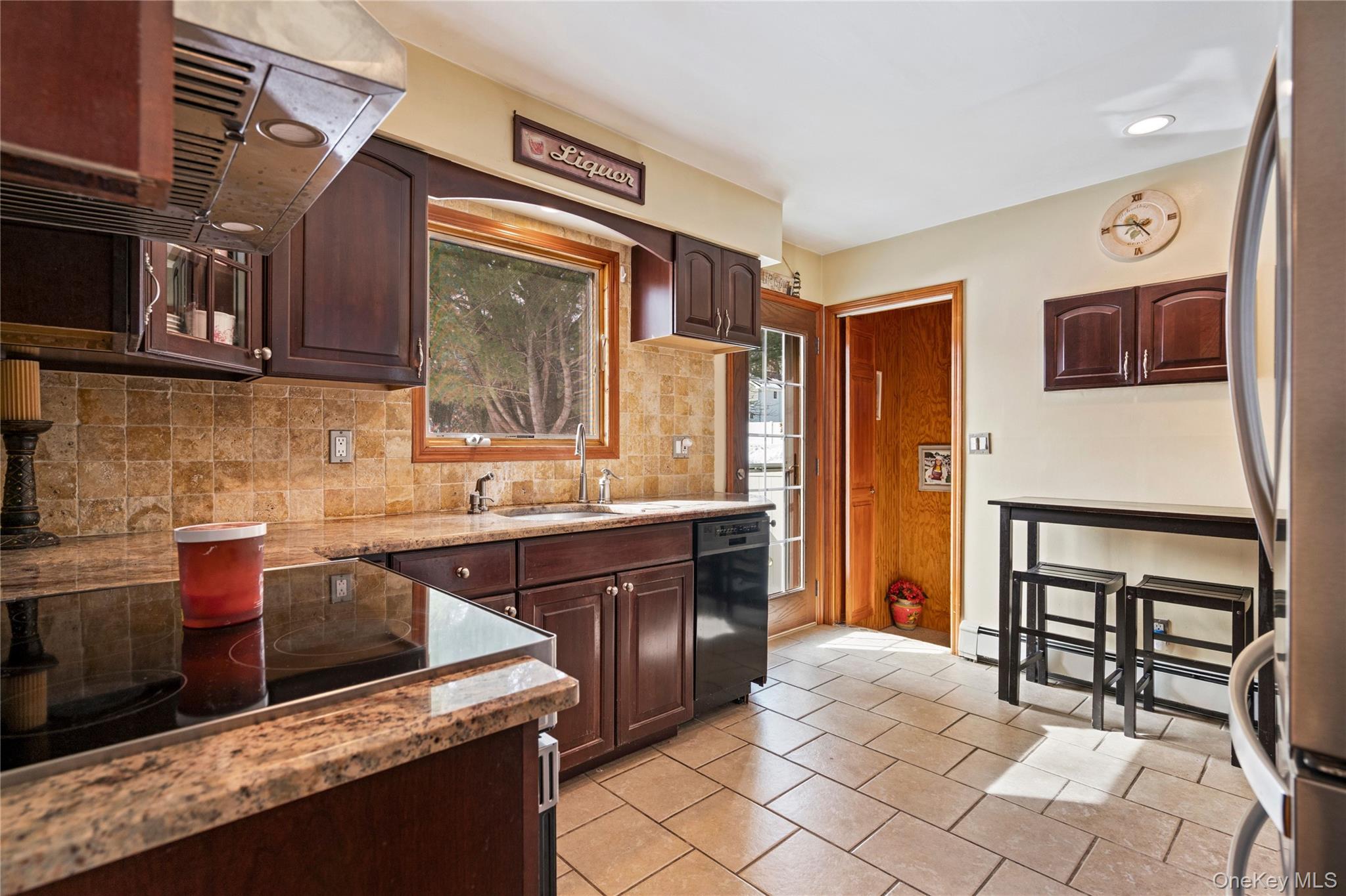 25 State Place Huntington, NY 11743 - Photo 17 of 33 a kitchen with stainless steel appliances granite countertop a stove a sink and a microwave