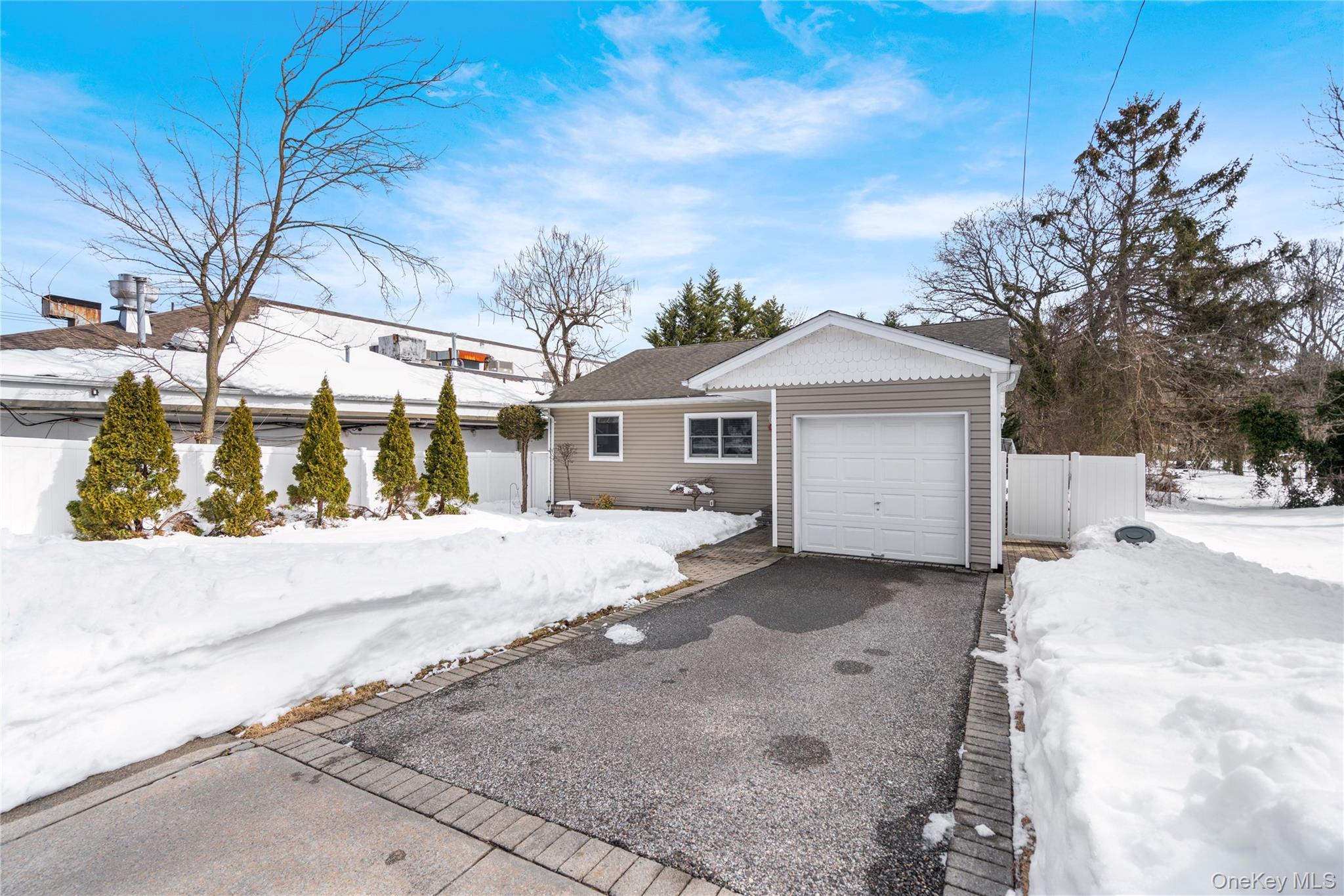 25 State Place Huntington, NY 11743 - Photo 2 of 33 a front view of a house with a yard and garage