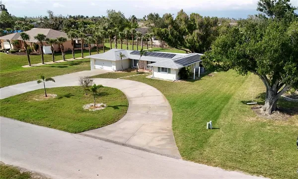 an aerial view of a house with garden space and trees