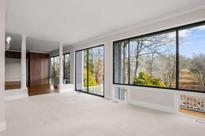 87 Lambert Road New Canaan, CT 06840 - Photo 14 of 39 an empty room with large windows and pool