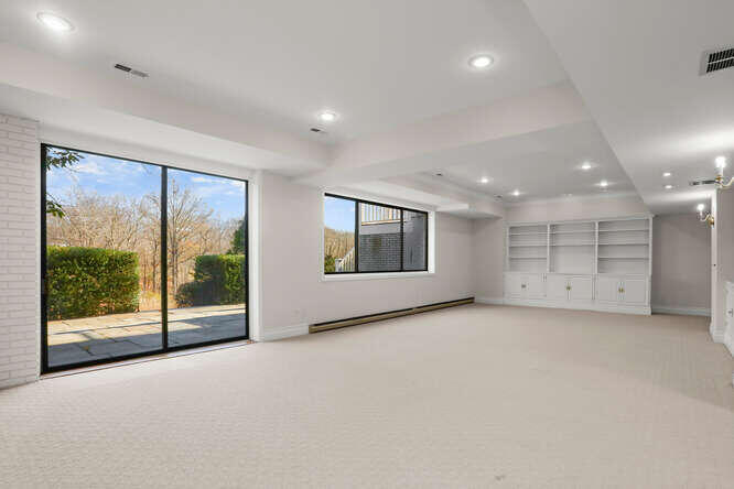 87 Lambert Road New Canaan, CT 06840 - Photo 22 of 39 an empty room with a fireplace and large window