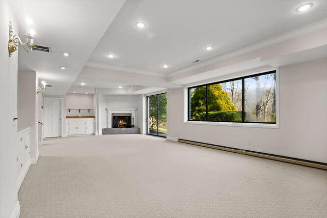 87 Lambert Road New Canaan, CT 06840 - Photo 23 of 39 a view of an empty room with a fireplace and a window