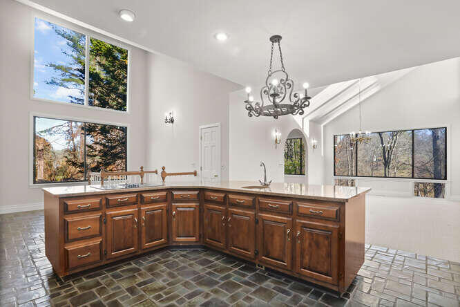 87 Lambert Road New Canaan, CT 06840 - Photo 7 of 39 a large kitchen with a sink and dishwasher with chairs