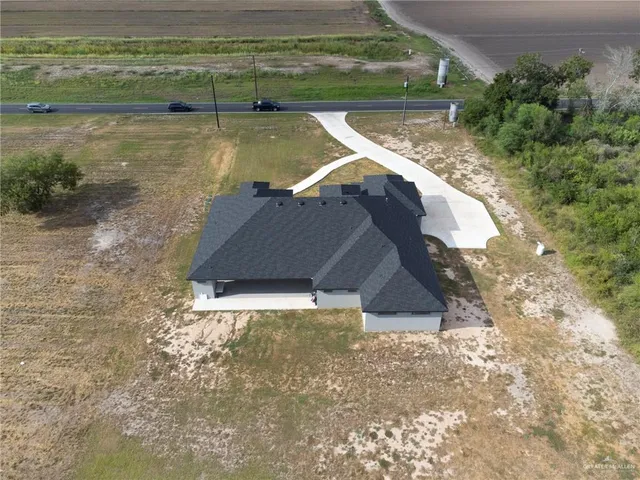 a view of a backyard with lawn chairs under an umbrella