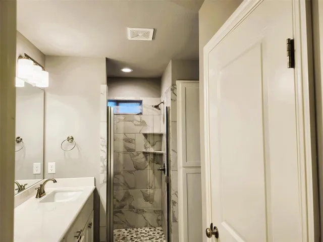 a bathroom with a shower sink and mirror