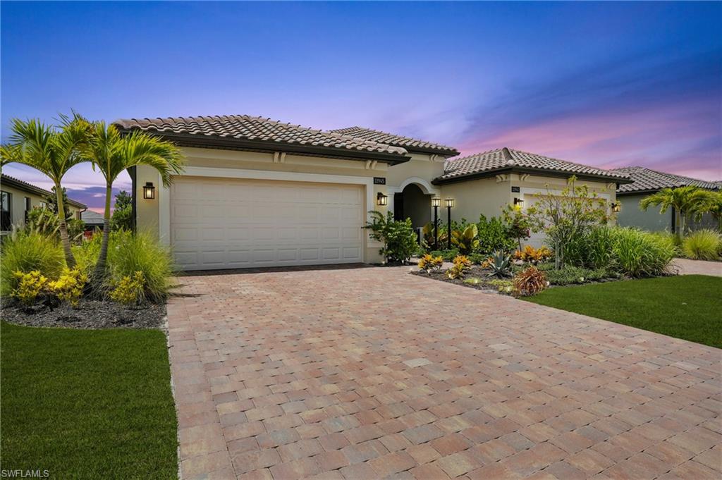Mediterranean / spanish house with stucco siding, decorative driveway, a garage, and a tile roof