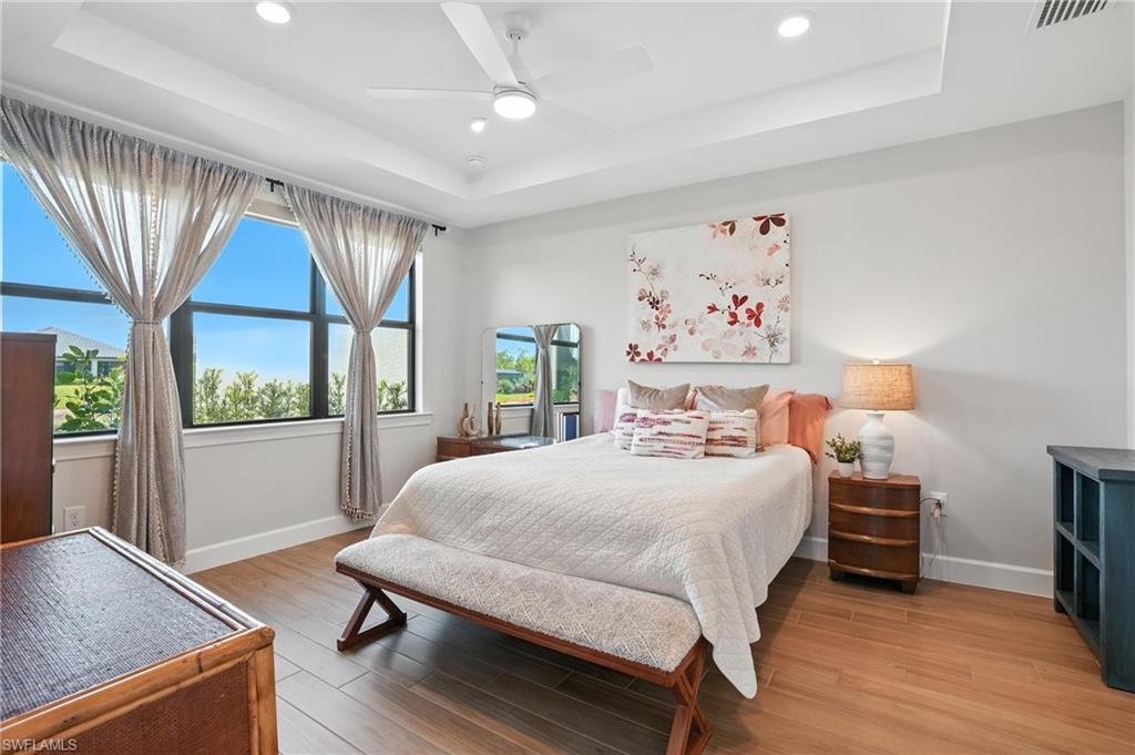 11945 Sacra Place Fort Myers, FL 33913 - Photo 19 of 50 Bedroom featuring a raised ceiling, light wood-style flooring, recessed lighting, and ceiling fan