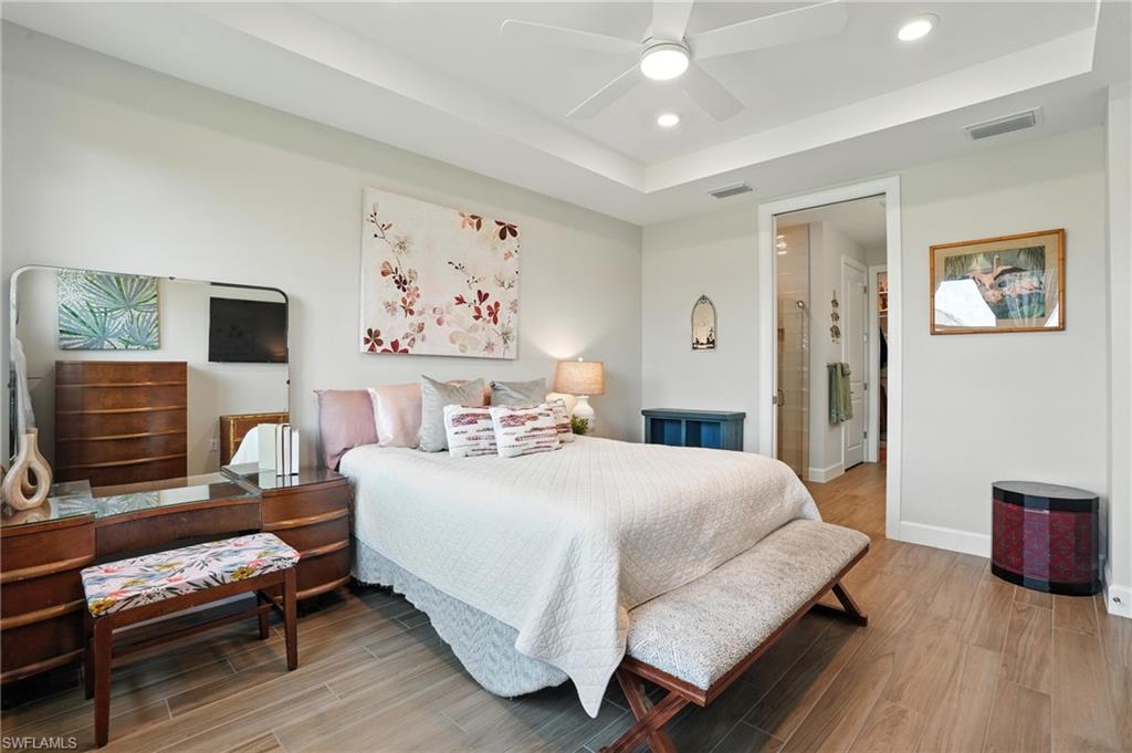 11945 Sacra Place Fort Myers, FL 33913 - Photo 21 of 50 Bedroom featuring light wood finished floors, a raised ceiling, recessed lighting, and ceiling fan