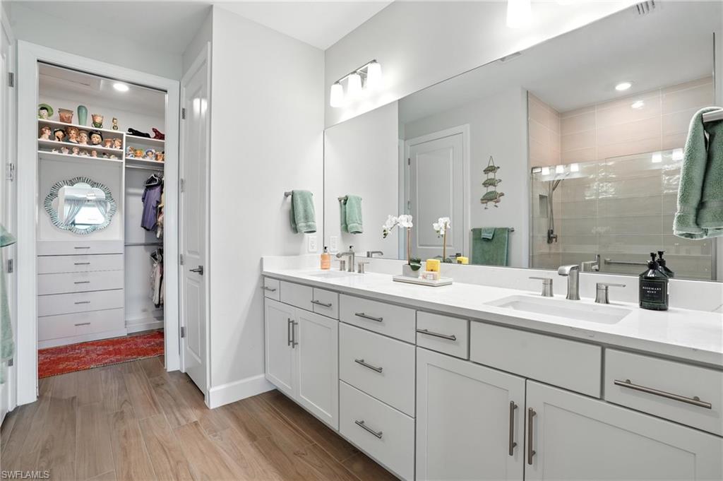 11945 Sacra Place Fort Myers, FL 33913 - Photo 22 of 50 Full bath featuring double vanity, a stall shower, wood finished floors, and a spacious closet