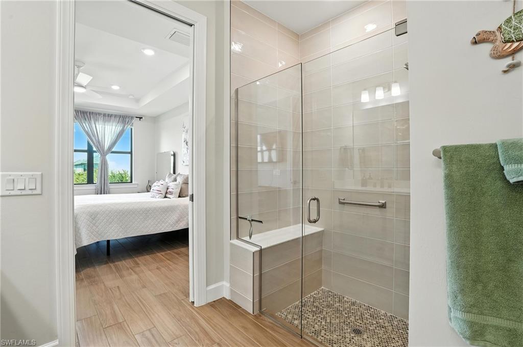 11945 Sacra Place Fort Myers, FL 33913 - Photo 23 of 50 Bathroom with wood finished floors, a stall shower, ensuite bathroom, recessed lighting, and a raised ceiling
