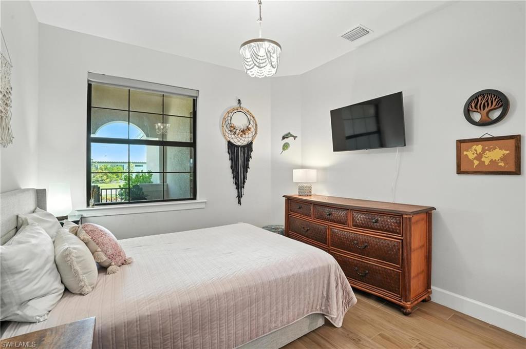 11945 Sacra Place Fort Myers, FL 33913 - Photo 25 of 50 Bedroom featuring light wood-type flooring and a chandelier