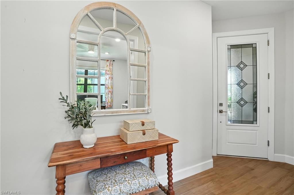 11945 Sacra Place Fort Myers, FL 33913 - Photo 7 of 50 Foyer featuring wood finished floors and baseboards