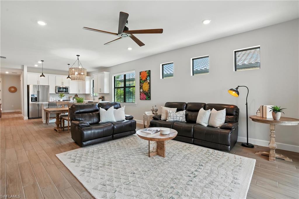 11945 Sacra Place Fort Myers, FL 33913 - Photo 8 of 50 Living room with ceiling fan, light wood finished floors, recessed lighting, and a chandelier