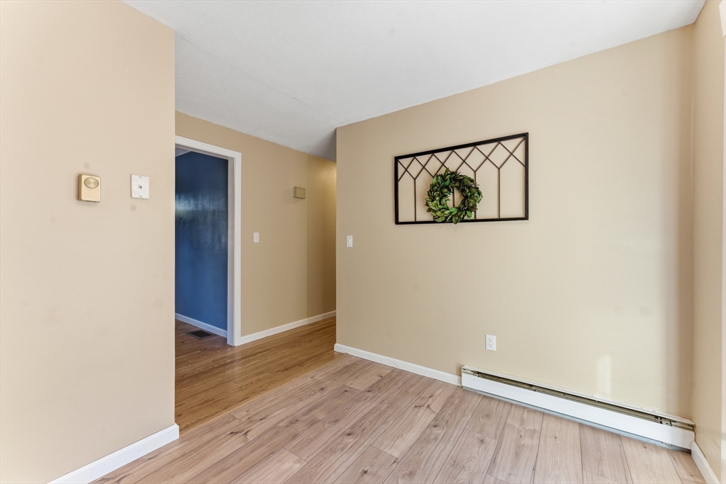 22 Phelps Street Easthampton, MA 01027 - Photo 17 of 42 an empty room with wooden floor and door
