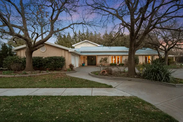 a front view of a house with a yard and trees