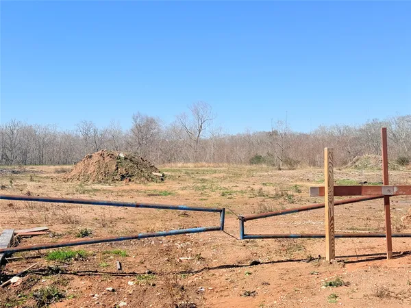 a view of a yard with wooden fence