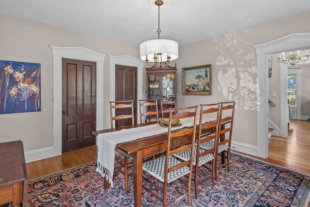 1881 Main Road Westport, MA 02791 - Photo 12 of 42 a dining room with wooden floor a chandelier a wooden table and chairs