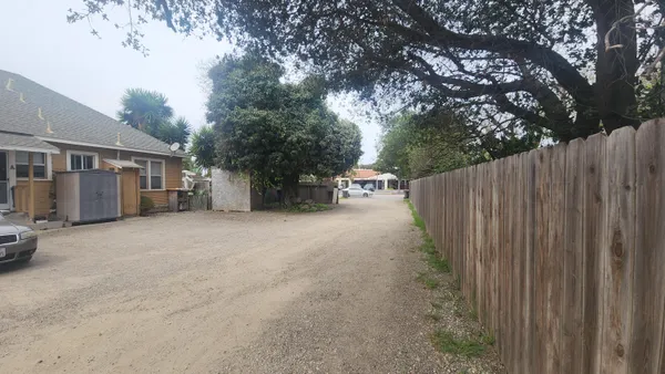 a view of a house with backyard and trees