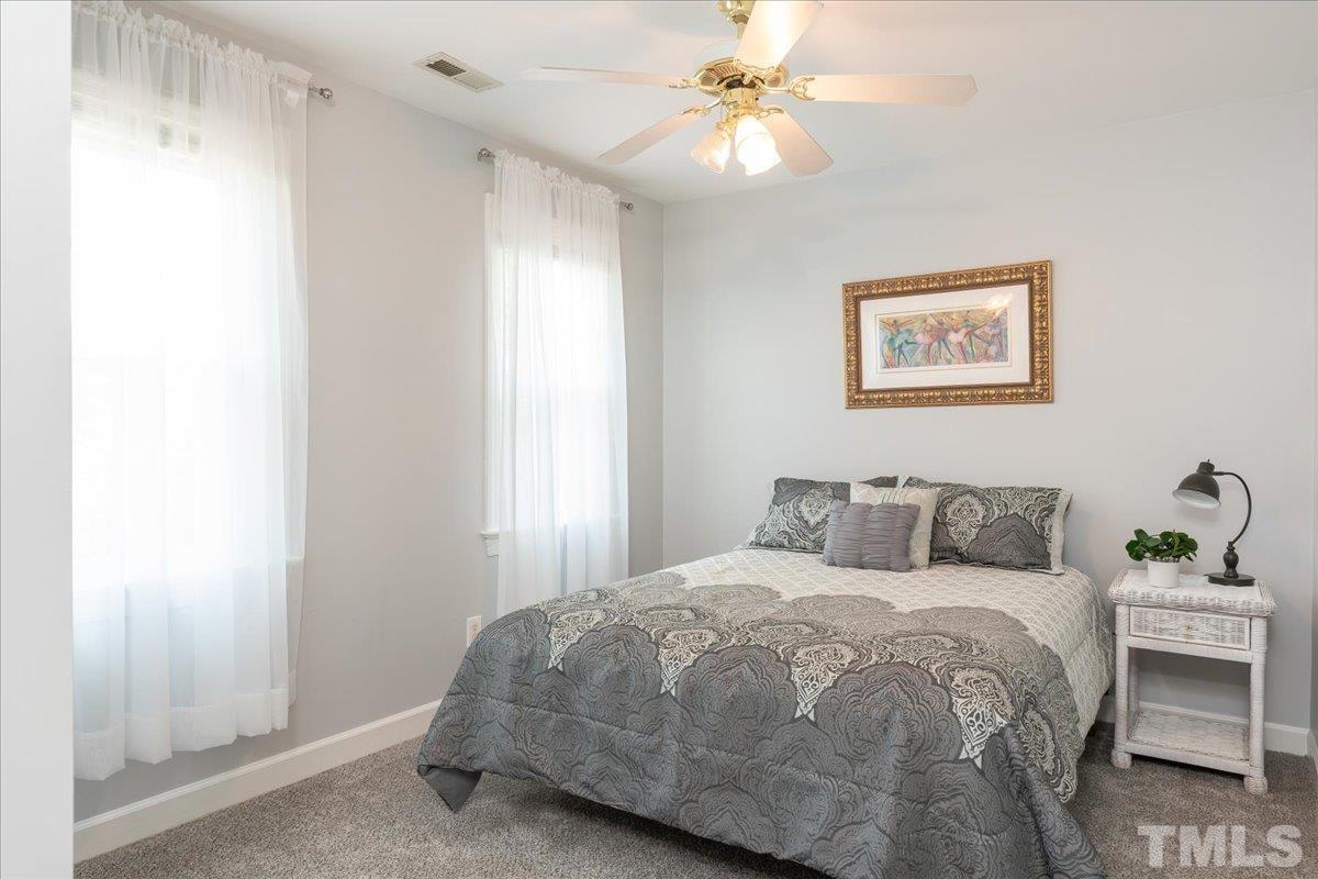 908 Broadhaven Drive Raleigh, NC 27603 - Photo 15 of 33 a bedroom with a bed and a chandelier