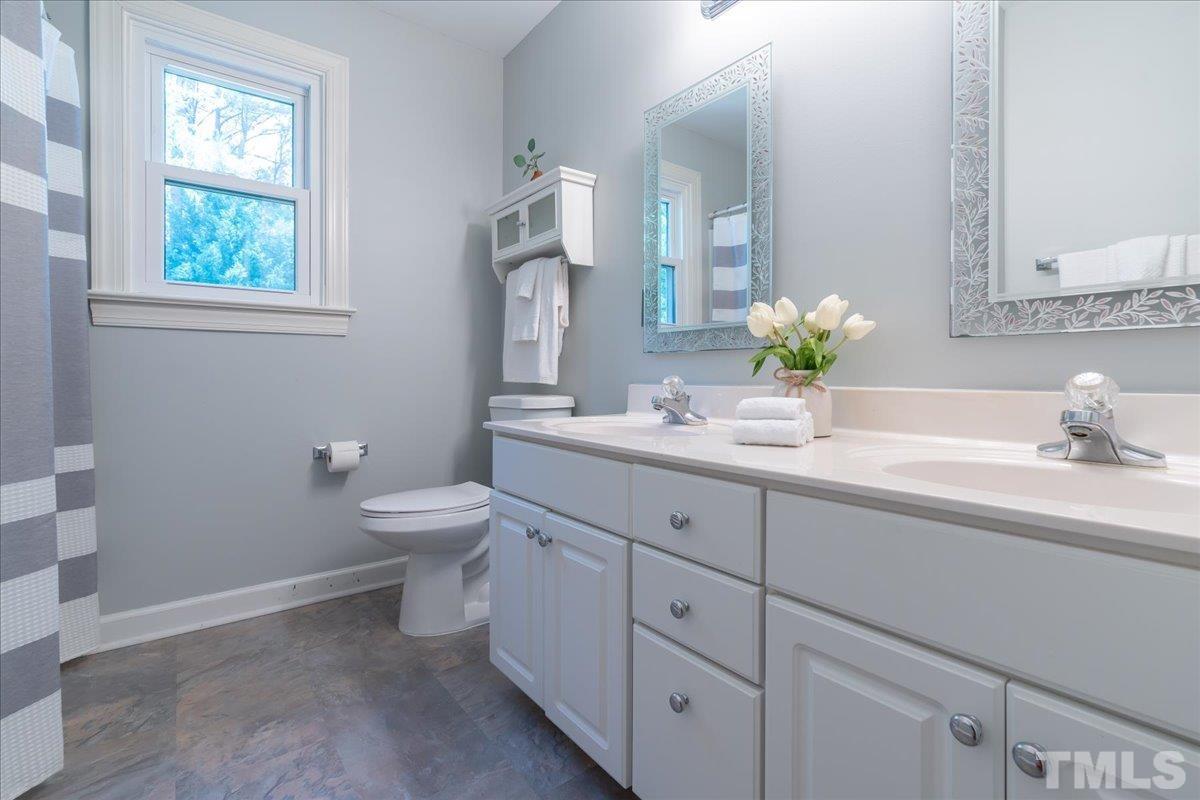 908 Broadhaven Drive Raleigh, NC 27603 - Photo 16 of 33 a bathroom with a granite countertop toilet sink and mirror