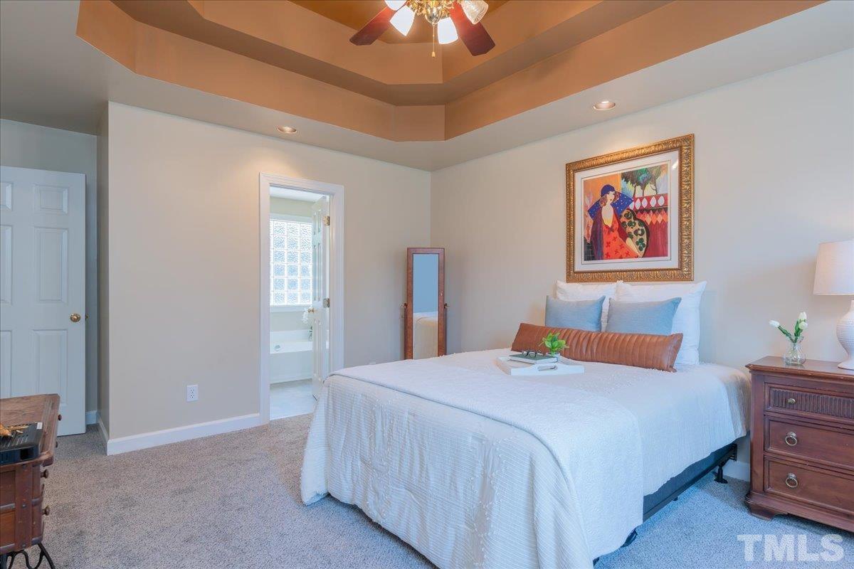 908 Broadhaven Drive Raleigh, NC 27603 - Photo 21 of 33 a bedroom with a bed and a chandelier