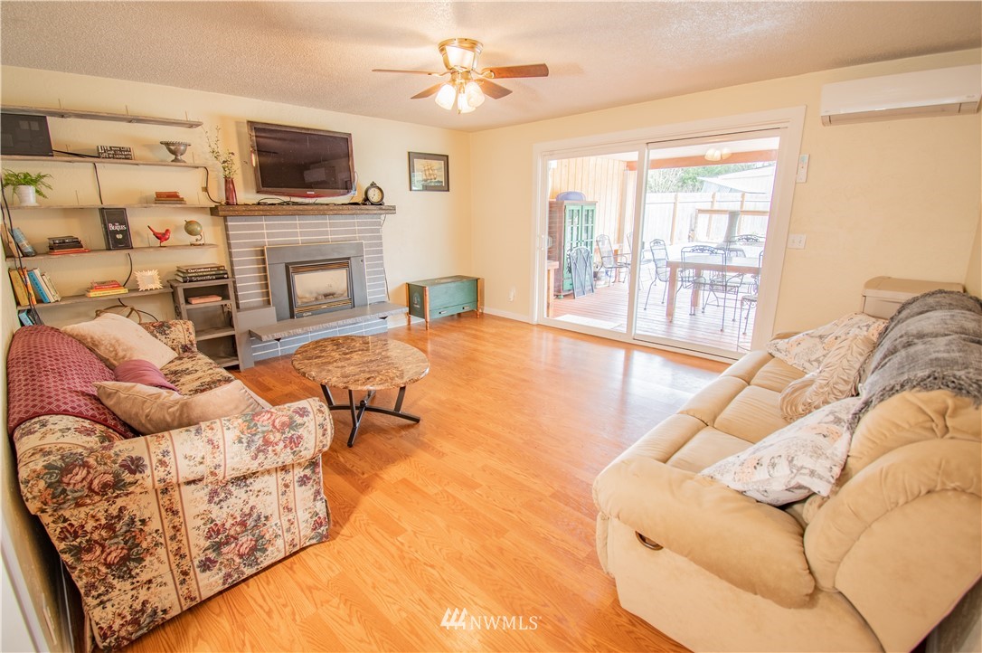 18428 Melon Street Southwest Rochester, WA 98579 - Photo 14 of 19 a living room with furniture a flat screen tv and a fireplace