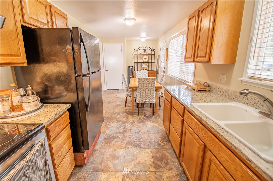 18428 Melon Street Southwest Rochester, WA 98579 - Photo 4 of 19 a kitchen with granite countertop a sink stove and refrigerator