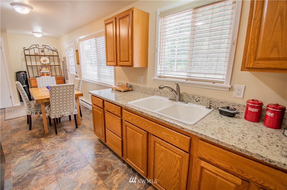 18428 Melon Street Southwest Rochester, WA 98579 - Photo 5 of 19 a kitchen with granite countertop sink and cabinets